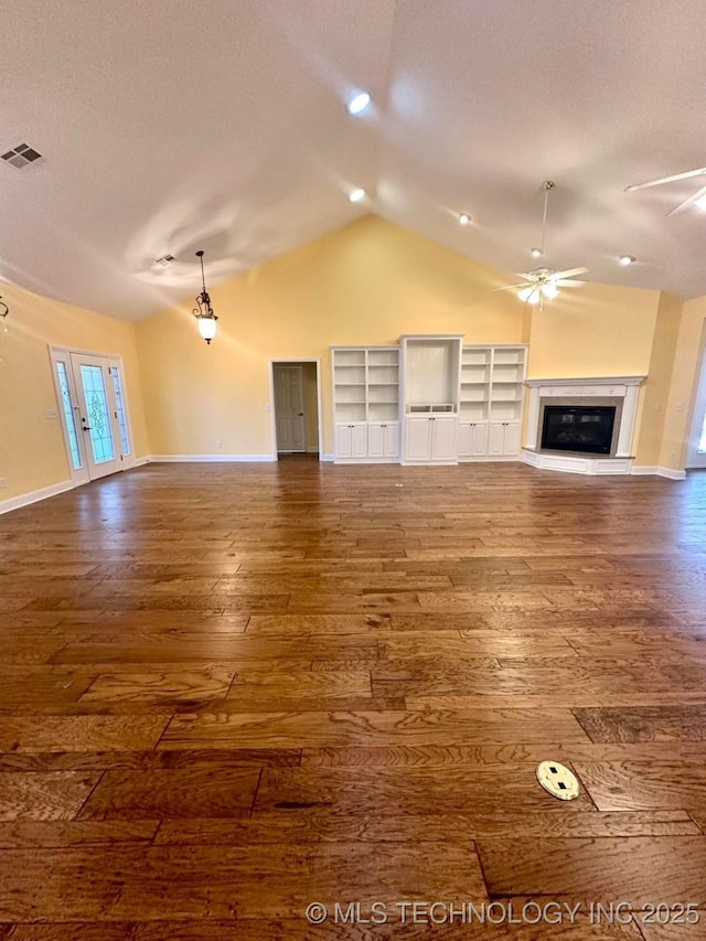 unfurnished living room with a textured ceiling, ceiling fan, wood-type flooring, and lofted ceiling