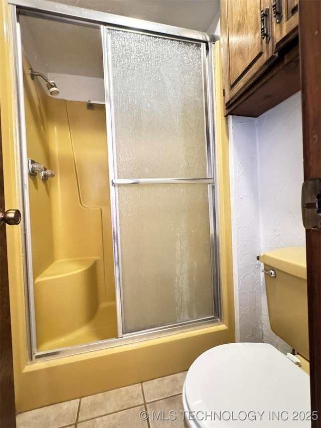 bathroom with tile patterned floors, toilet, and walk in shower