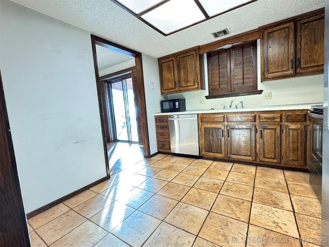 kitchen featuring light tile patterned floors and stainless steel dishwasher