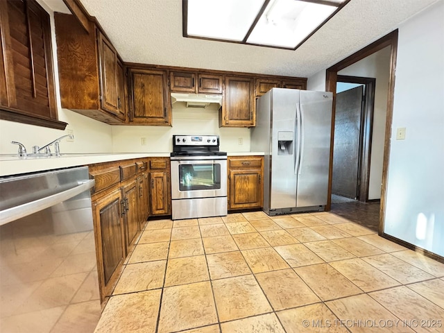 kitchen featuring a textured ceiling, sink, and stainless steel appliances