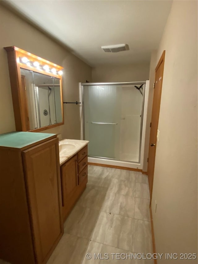 bathroom with a shower with door and vanity