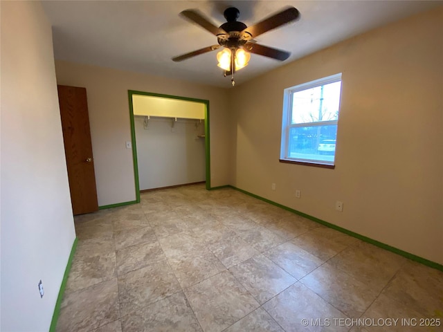 unfurnished bedroom featuring ceiling fan and a closet