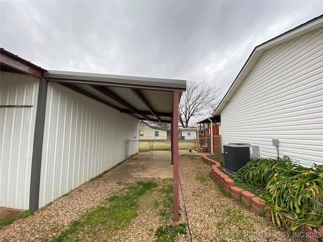 view of yard featuring central AC and a carport