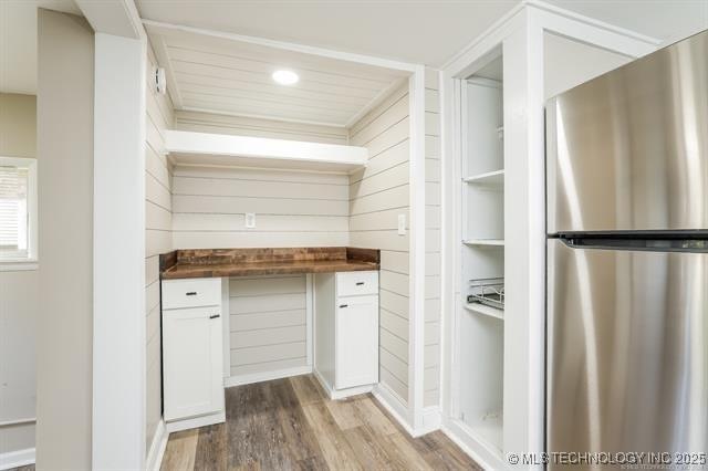 kitchen featuring stainless steel refrigerator, hardwood / wood-style flooring, white cabinets, and wood counters