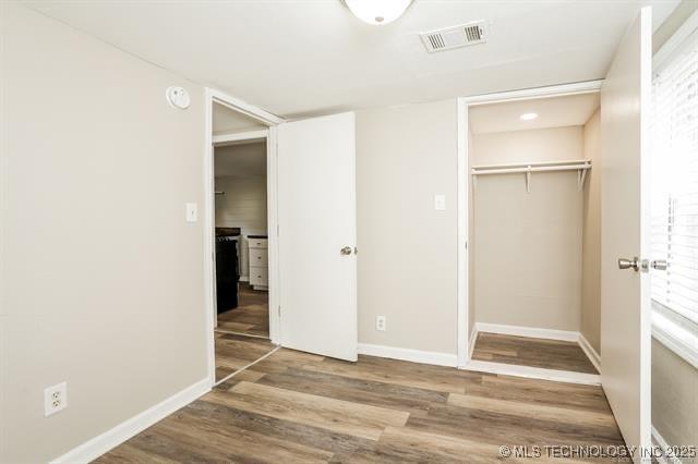 unfurnished bedroom featuring hardwood / wood-style floors and a closet