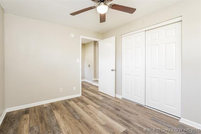 unfurnished bedroom with hardwood / wood-style floors, a closet, and ceiling fan