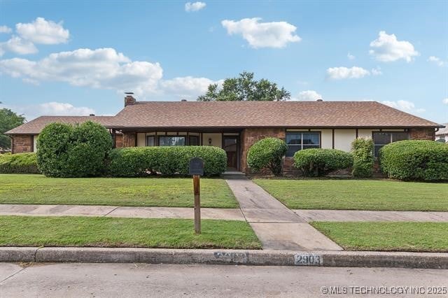 ranch-style home with a front lawn