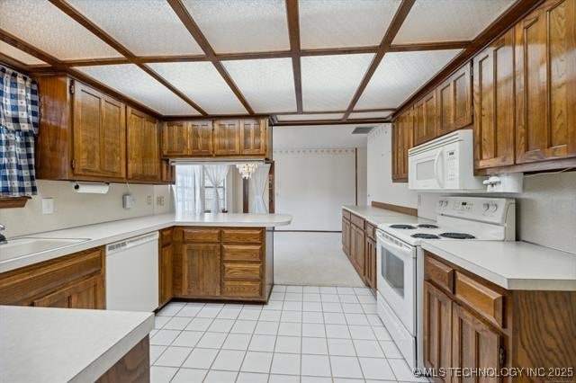 kitchen with sink, white appliances, and kitchen peninsula