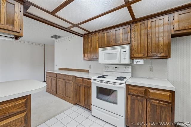 kitchen featuring light tile patterned flooring and white appliances