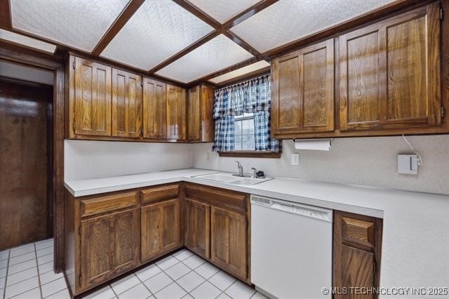 kitchen featuring white dishwasher, light tile patterned floors, and sink