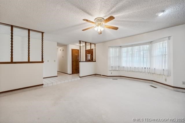 spare room with ceiling fan, light carpet, and a textured ceiling