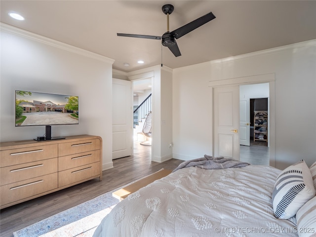 bedroom with wood-type flooring, ceiling fan, and ornamental molding