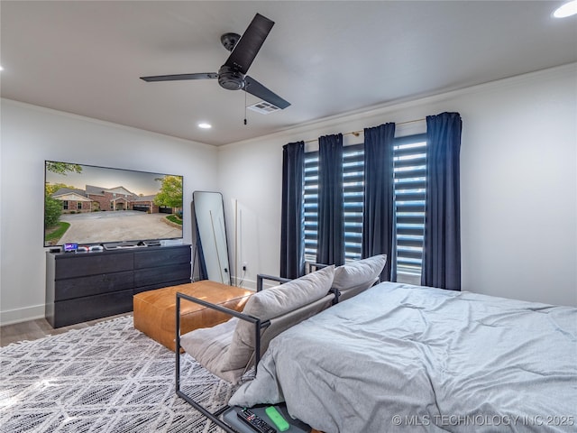 bedroom with hardwood / wood-style floors, ceiling fan, and crown molding