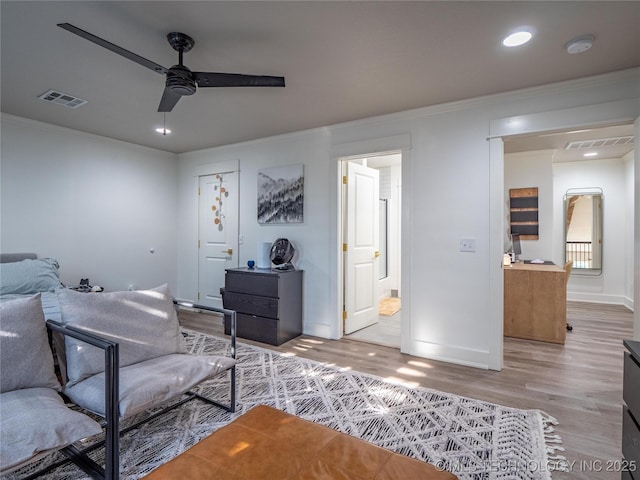 interior space featuring ceiling fan, ornamental molding, and light hardwood / wood-style flooring