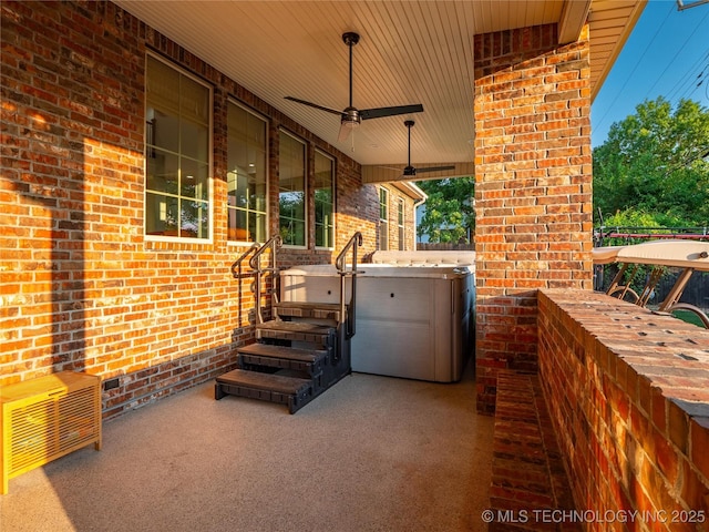 view of patio with ceiling fan and a hot tub