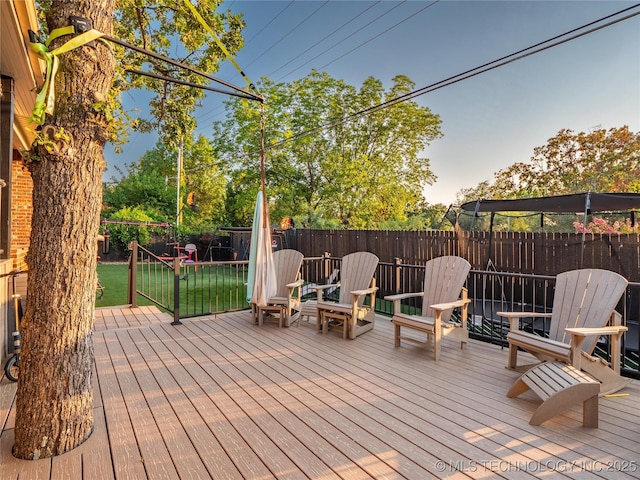 wooden terrace featuring a lawn