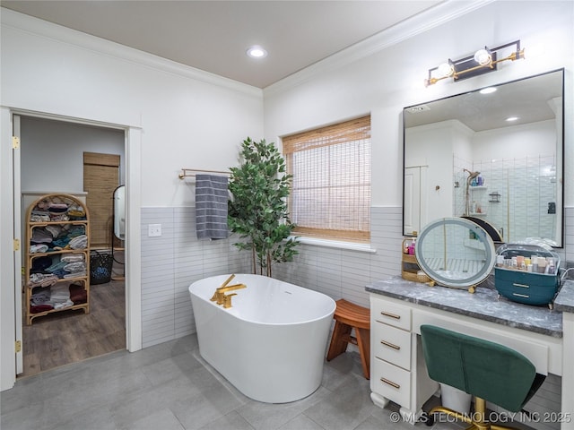 bathroom with vanity, plus walk in shower, tile patterned floors, ornamental molding, and tile walls