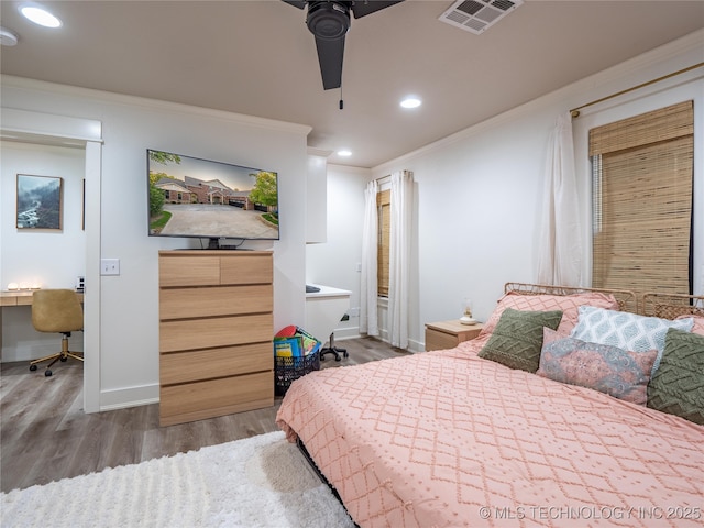 bedroom featuring wood-type flooring, connected bathroom, ceiling fan, and ornamental molding