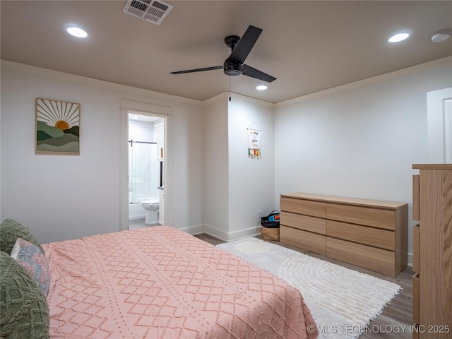 bedroom featuring hardwood / wood-style floors, ensuite bath, ceiling fan, and ornamental molding