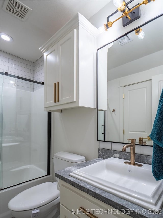 full bathroom featuring vanity, toilet, and combined bath / shower with glass door