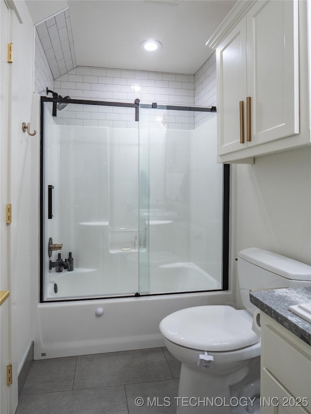 full bathroom with shower / bath combination with glass door, tile patterned flooring, vanity, and toilet