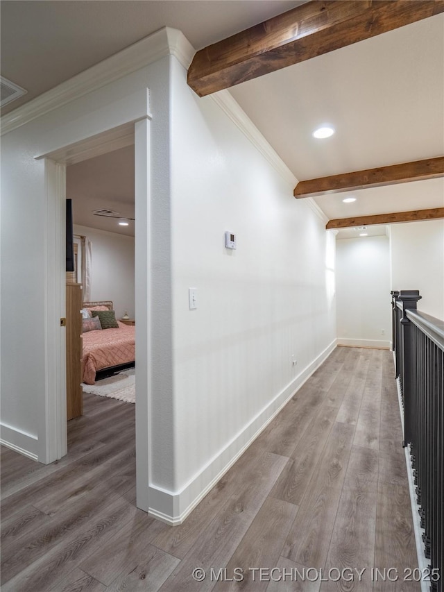 hallway with beamed ceiling, wood-type flooring, and ornamental molding