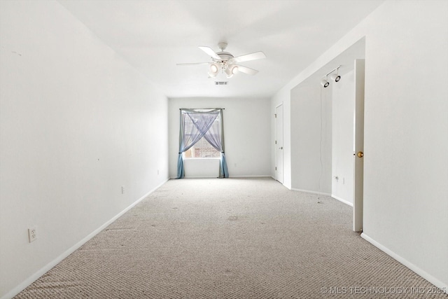 spare room featuring light colored carpet and ceiling fan