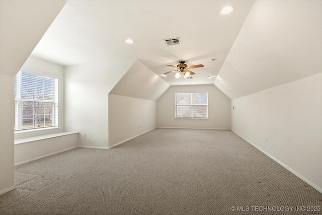 additional living space featuring ceiling fan, light colored carpet, and lofted ceiling