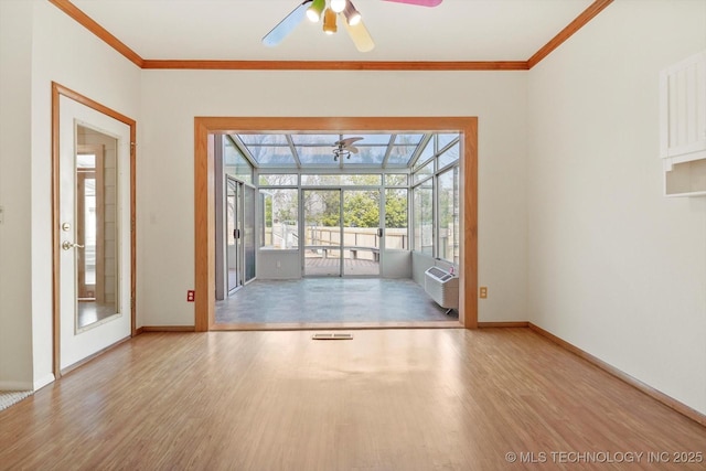 doorway featuring light hardwood / wood-style floors, an AC wall unit, ceiling fan, and ornamental molding