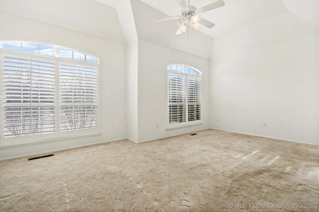 carpeted empty room with ceiling fan and vaulted ceiling