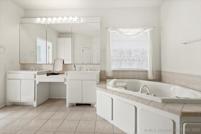 bathroom with a washtub, tile patterned flooring, and vanity