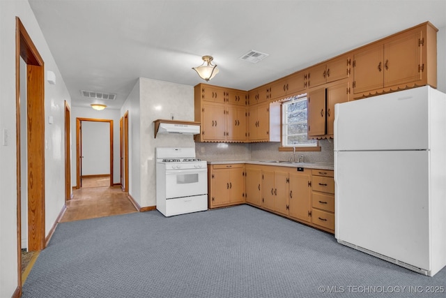 kitchen featuring tasteful backsplash, white appliances, light colored carpet, and sink