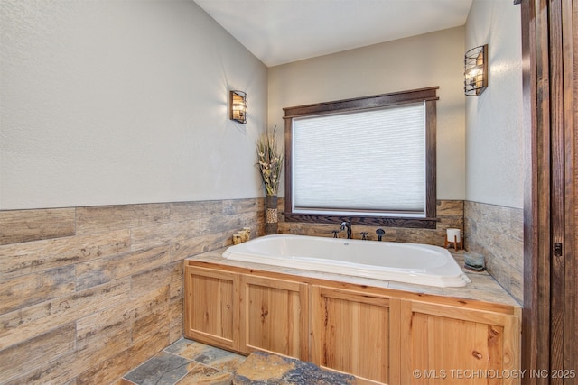 bathroom featuring tile walls and a bathing tub