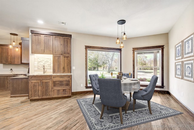 dining area with sink and light hardwood / wood-style floors