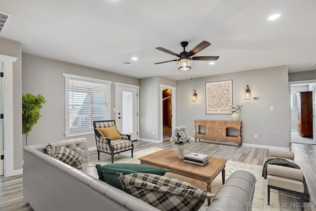 living room with ceiling fan and light hardwood / wood-style floors