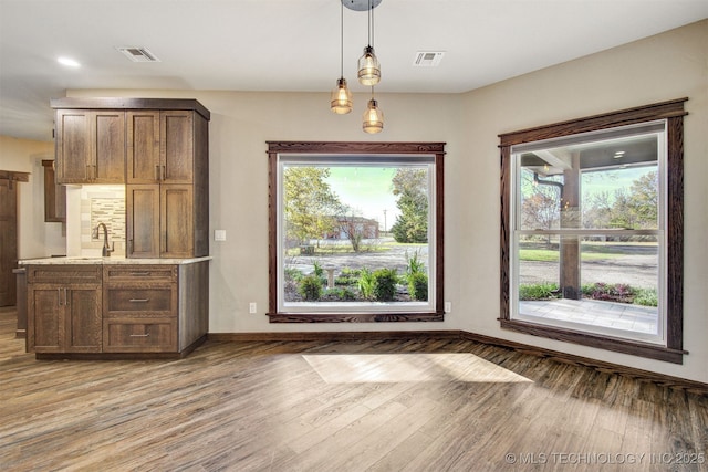 unfurnished dining area with sink and light hardwood / wood-style flooring