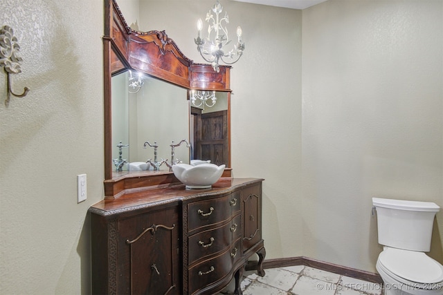 bathroom with vanity, an inviting chandelier, and toilet