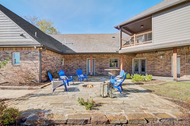 view of patio featuring a fire pit and a balcony