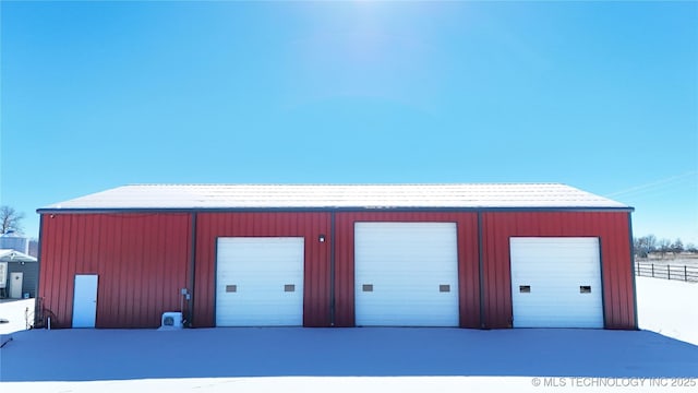 snow covered structure featuring a garage