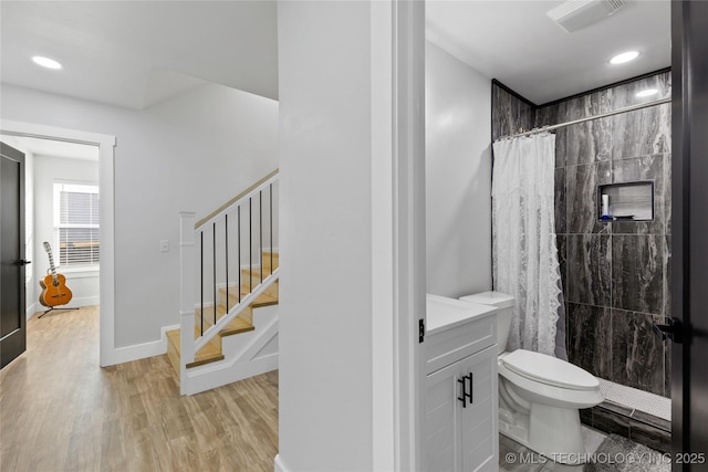 bathroom featuring curtained shower, vanity, wood-type flooring, and toilet