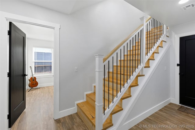 stairs featuring wood-type flooring