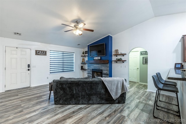 living room with hardwood / wood-style flooring, vaulted ceiling, and ceiling fan