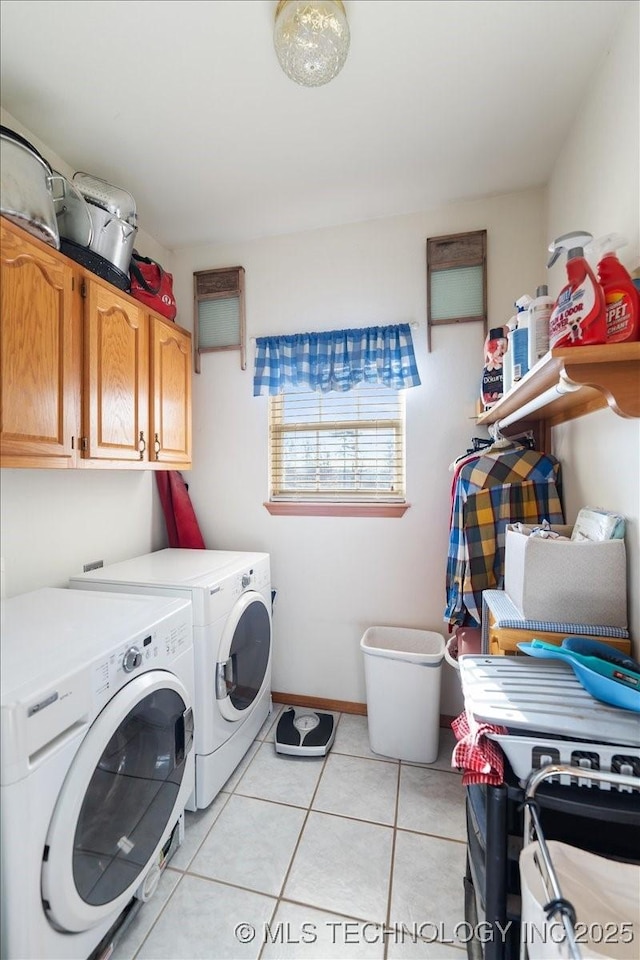 clothes washing area featuring separate washer and dryer, light tile patterned floors, and cabinets