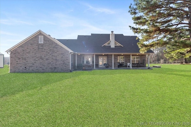 rear view of property featuring a lawn