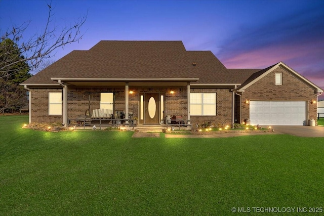 view of front facade with a porch, a garage, and a yard