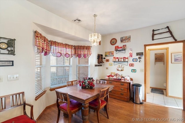 dining area with a chandelier and light wood-type flooring