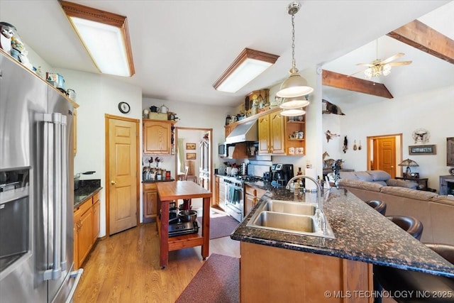 kitchen with exhaust hood, lofted ceiling with beams, sink, appliances with stainless steel finishes, and light hardwood / wood-style floors