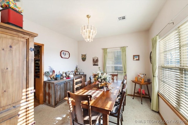 carpeted dining area featuring a chandelier