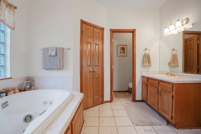 bathroom featuring vanity, tiled bath, tile patterned floors, and toilet