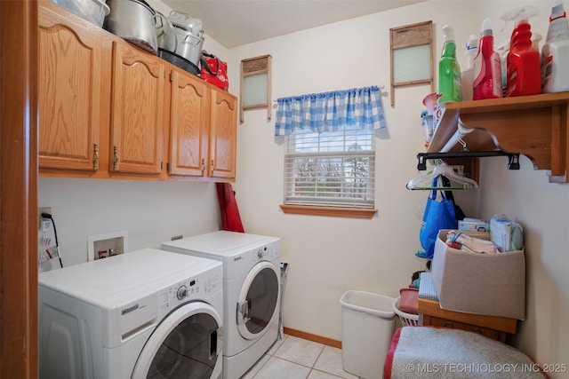 washroom featuring cabinets, washing machine and dryer, and light tile patterned floors